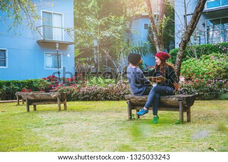 Asian couple smiled and was happy with the book read. Among the beautiful flower gardens, Valentine