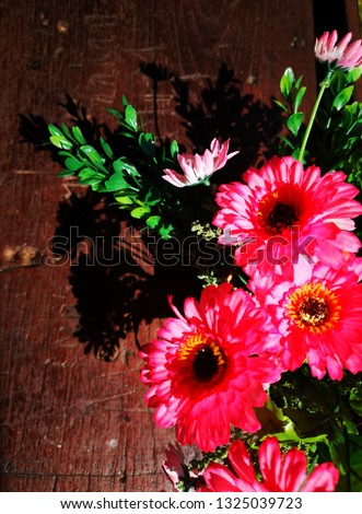 Beautiful red artificial flower bouquet, brown background