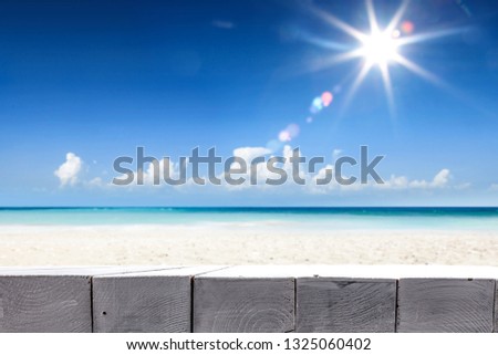 Wooden table of free space for your decoration. Beach landscape with blue sea and summer sun on sky. 