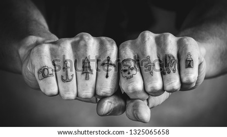Close up of tattoos on fingers and knuckles.