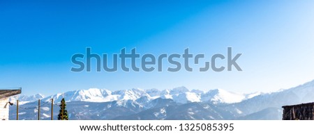A beautiful view of the Polish Tatra Mountains. Sunny, beautiful day in the winter, snow-capped mountains and blue sky.