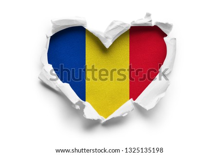 Heart shaped hole torn through paper, showing satin texture of flag of Romania. Isolated on white background