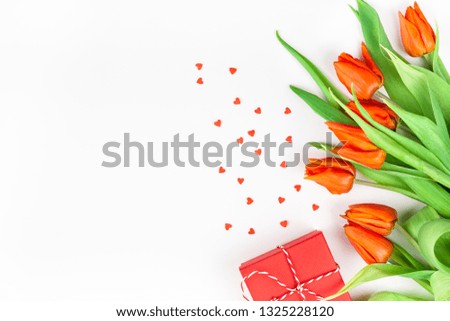 Creative flat lay top view welcome spring greeting card with red tulips flowers on white background with copy space. Celebration Postcard template