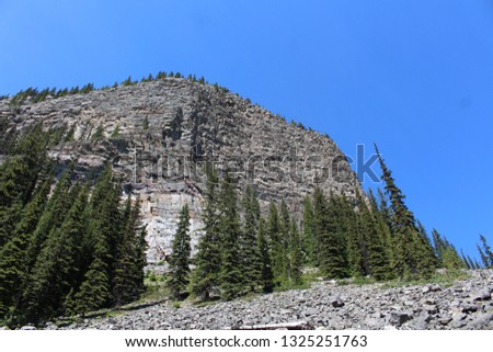 Dramatic mountains on a sunny day with blue sky and green trees