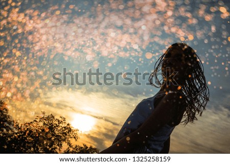Silhouette of braided hair teenage girl turning around /
Urban sunset scene. Millennial Generation
