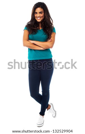 Stylish young female posing before the camera with folded arms, bright smile.