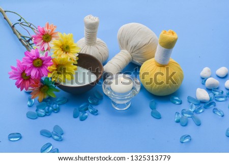 Spa setting on blue background with,salt in bowl, stones, with herbal ball, rainbow, Chrysanthemum
