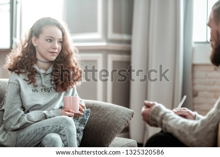 Relieved at counseling. Pleasant appealing curly teenager feeling relieved during counseling Royalty-Free Stock Photo #1325320586