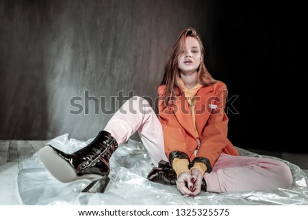 Leather shoes. Delighted girl sitting on floor and having rest after shooting