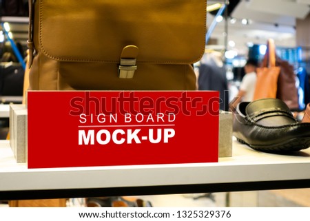 Mock up horizontal blank signboard with clipping path in acrylic stand to show price or promotion male shoes, red screen empty space for promotion or advertising in men's clothing store 