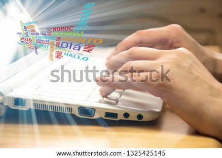 A woman at the computer and the word Hello in different languages