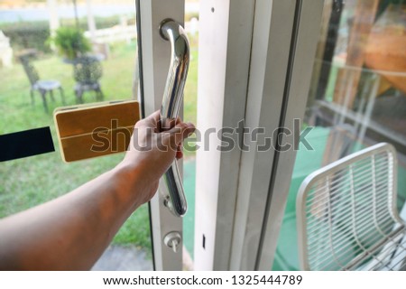 Hand holding handle sliding glass door with opening