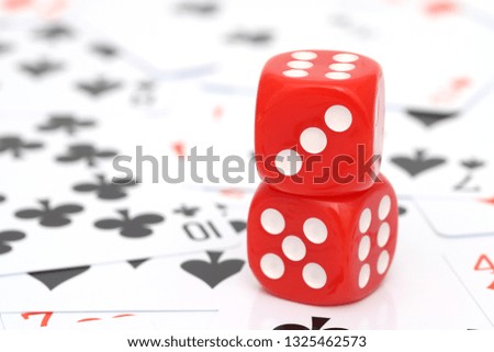 red dice with playing cards are on the background 