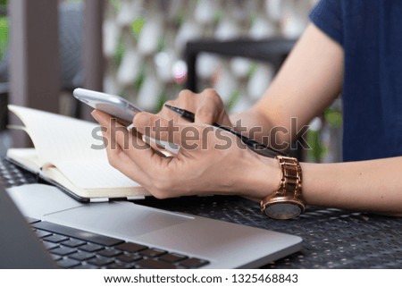 Businessman at workplace Think business investment plan.Contact Investor using cell phone,computer make note meeting of appointment information in the notebook.design creative work space