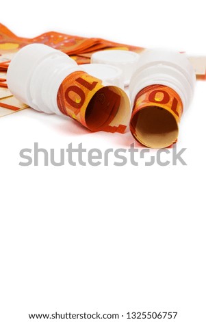 Symbolic picture for high cost of medicine with pill bottle on money (10 euro banknotes). Rolled euro banknotes in white pill bottle. Medical concept. Copy space for text.