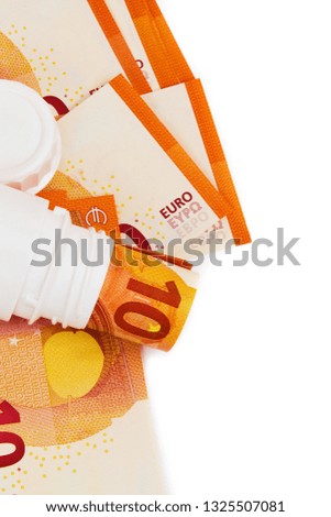 Symbolic picture for high cost of medicine with pill bottle on money (10 euro banknotes). Rolled euro banknotes in white pill bottle. Medical concept. Copy space for text. Top view.