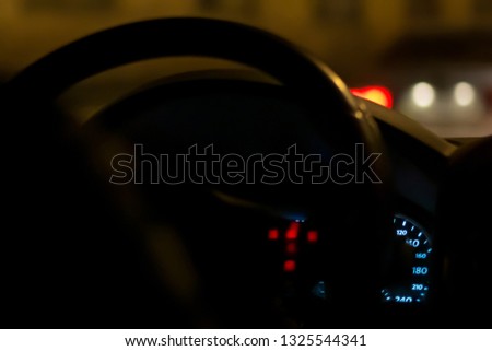 Car dashboard and speedometer, at night, closeup