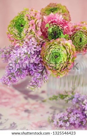 A beautiful bouquet of spring flowers with a lilac on a pink background.On the table with a beautiful tablecloth. Pastel colors.
