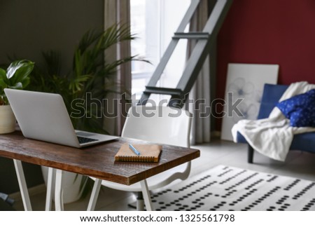 Workplace with laptop in stylish interior of room