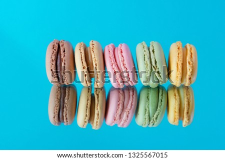 Tasty colorful macaroon homemade isolated on a mirror and a colorful background and reflections contemporary decoration