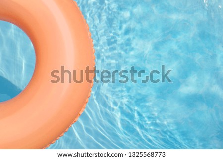 Coral rubber ring floating in pool, holiday summer relax