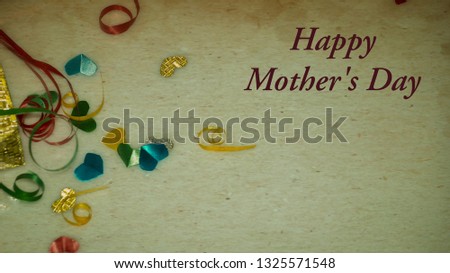 Happy Mother's Day words with Colourful heart shape ribbon and small gift boxes on colorful bokeh, flare background. Image noise and light leaks.