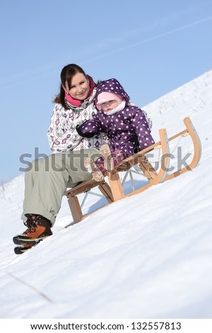 Mother with small girl going down in sleigh