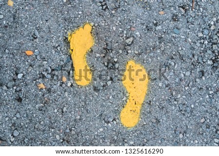 A Yellow footprint signs on the floor for pedestrian. Symbol of walkway.