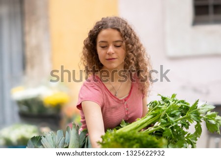 Young woman at the farmers market boying vegetables and fruit