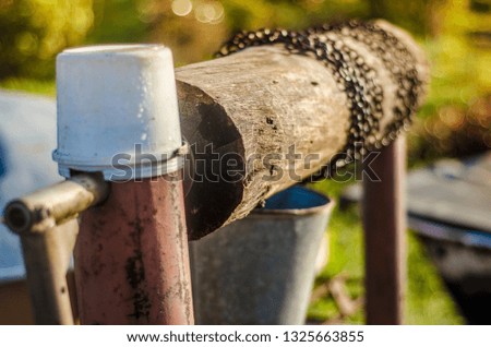 Beautiful view of the well. Many objects and products in the countryside. Old wooden well with spindle and rusty chain in the countryside in the morning and summer.