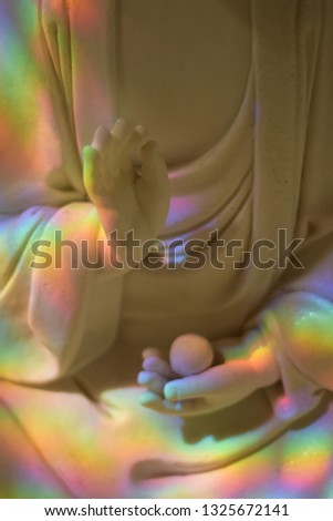Statue of the Buddha, monk with rainbow color sunlight in Vietnam, Ho Chi Minh City.