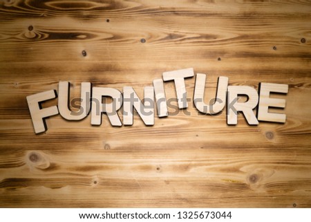FURNITURE word made of wooden block letters on wooden board.