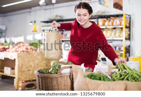 Woman choosing green beans in farm food store