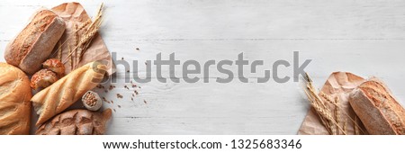 Different bakery products on wooden background with space for text Royalty-Free Stock Photo #1325683346