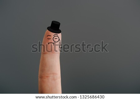 cropped view of one finger as gentleman in hat isolated on grey