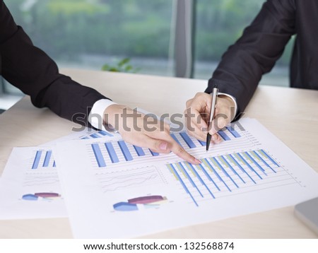 two business executives analyzing business performance in office.