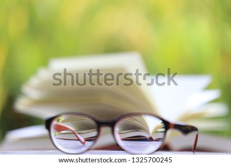Blurred images of open books viewed from the reflection of the glasses