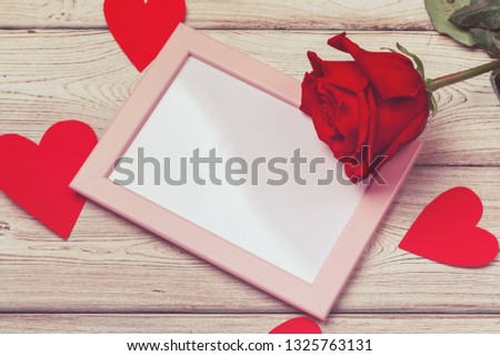 Valentines day photo frame or greeting card and handmaded hearts over table. Top view with copy space