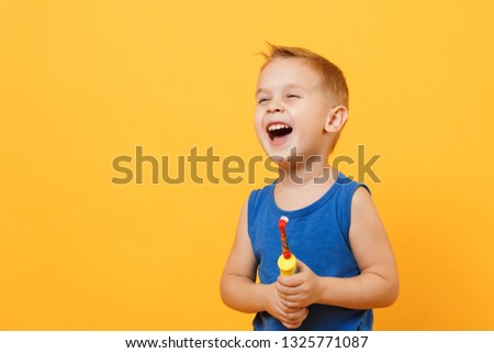 Kid boy 3-4 years old in blue shirt brush his teeth with toothbrush isolated on bright yellow orange wall background, children studio portrait. People, childhood lifestyle concept. Mock up copy space Royalty-Free Stock Photo #1325771087