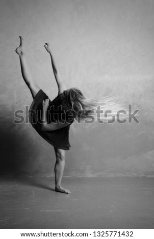 Young modern dancer exercising and dancing in loft studio Royalty-Free Stock Photo #1325771432