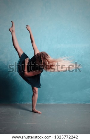 Young modern dancer exercising and dancing in blue studio Royalty-Free Stock Photo #1325772242