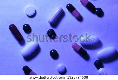 Heap of assorted various medicine tablets and pills different colors on white background. Pattern of pharmaceutical medicine pills, tablets and capsules.