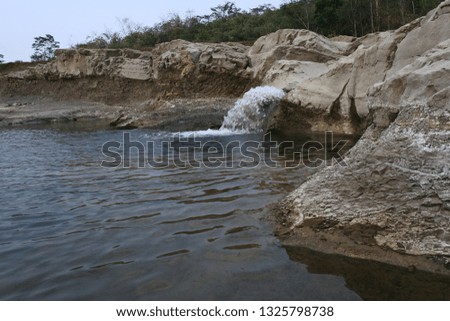 
water flows into the river rock slits
