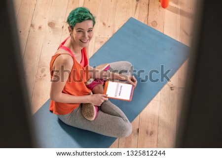 In the Internet. Cheerful appealing green-haired sportswoman searching image in the Internet