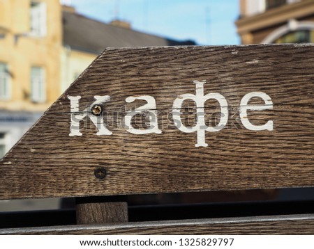 The inscription "cafe" in Ukrainian on a wooden plate