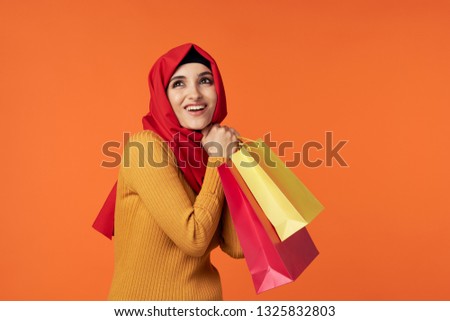 Pretty Muslim woman in red hijab on orange background Indonesia Islam Religion