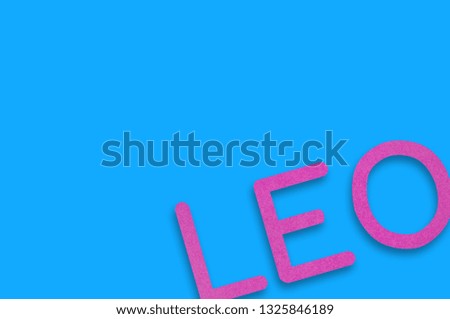 Word leo cut out of purple paper on blue table. Top view. Horoscope concept. Copy space for your text