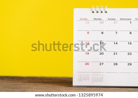 close up of calendar on the table with yellow background, planning for business meeting or travel planning concept