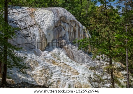 Natural hot springs. The thermal water at Bagni San Filippo have created a  landscape of white limestone formations, waterfalls and small pools of warm water in forest, Tuscany, Italy