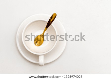 empty white of coffee cup with golden spoon isolated on white background